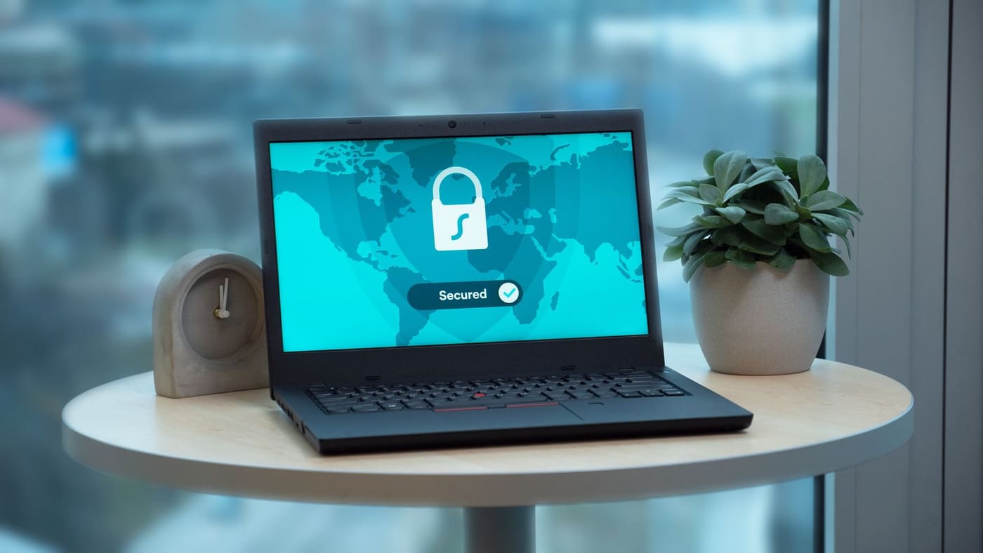 Laptop showing a padlock over a network map