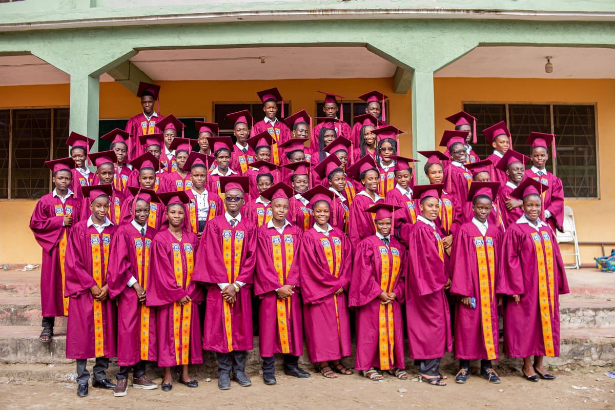 Graduates in gowns and caps outside a university building in Winneba, Ghana
